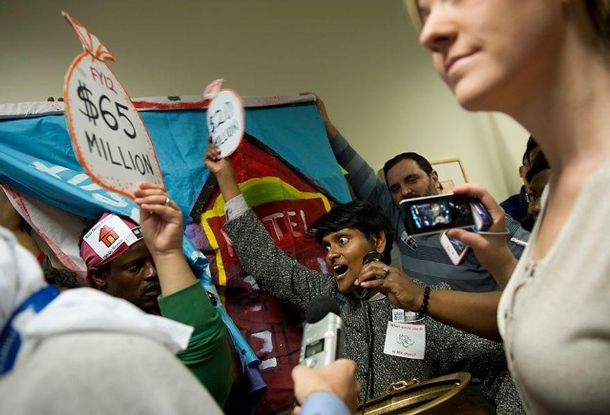 "Don't despair, the money's there," says Kesh Ladduwahetty (center), a volunteer with D.C. for Democracy, during a rally at the Wilson Building in Washington, D.C. on Thursday, May 10, 2012. She told D.C. Council Chairman Kwame Brown that there is $240 million in surplus funding from the FY 2011 budget, $65 million from the FY 2012 budget, and that the city could raise a potential $20 million more by increasing the alcohol excise tax. She and other community services organizations are hoping for $32 to $40 million in funding in the FY 2013 budget for things like affordable housing and homeless services. (Barbara L. Salisbury/The Washington Times)