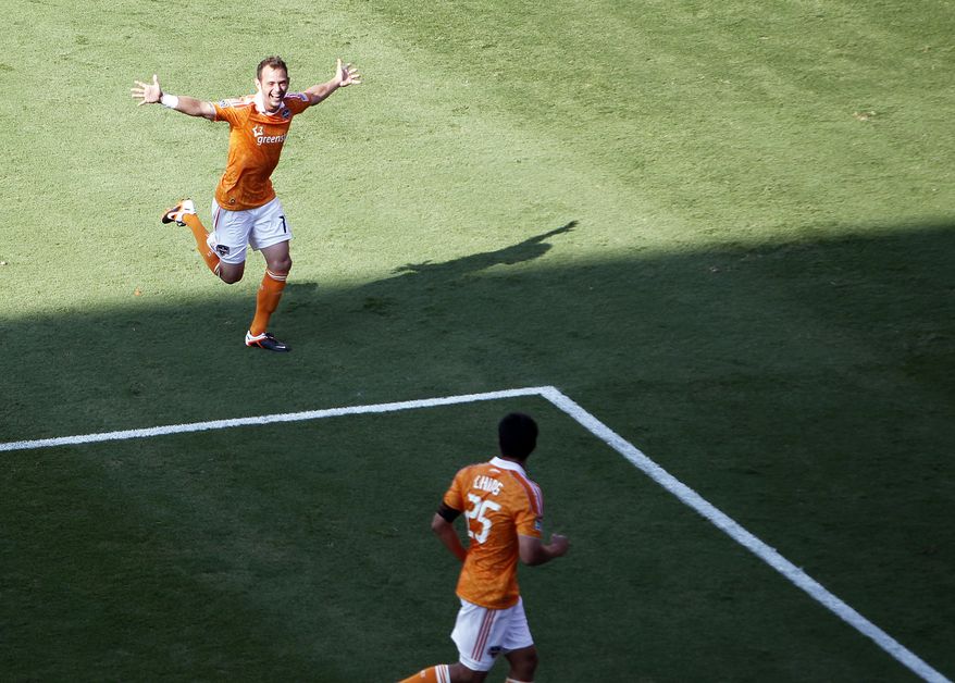 Houston Dynamo's Brad Davis, left, celebrates after scoring a goal against D.C. United as teammate Brian Ching watches during the second half Saturday, May 12, 2012, in Houston. (AP Photo/Houston Chronicle, James Nielsen)
