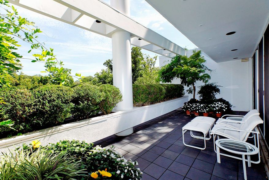 The terrace off the master bedroom has a row of boxwoods for privacy.