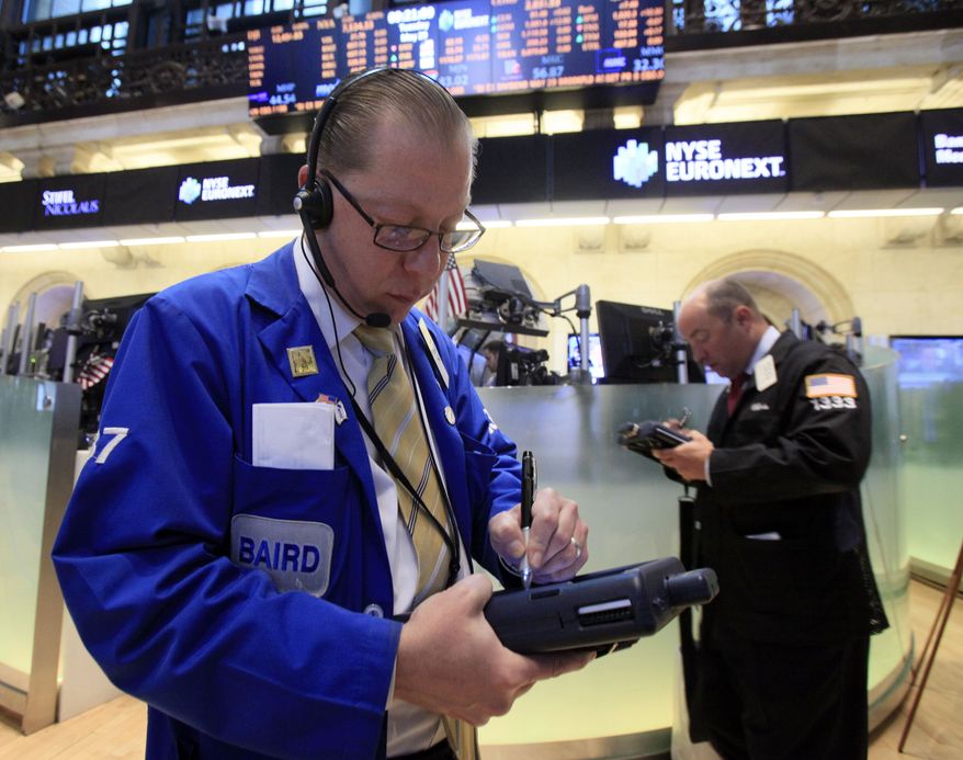 Trader Edward Radziewicz (left) works May 29, 2012, on the floor of the New York Stock Exchange. (Associated Press)