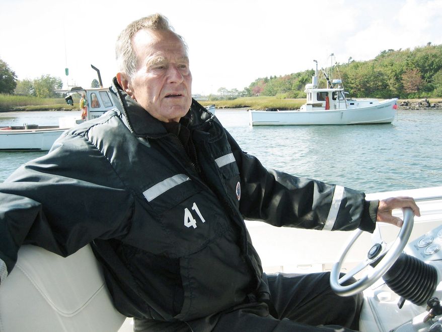 Former President George H.W. Bush takes the wheel of his boat in Kennebunkport, Maine, during the filming of the documentary "41," which premieres Thursday on HBO. (HBO via Associated Press)