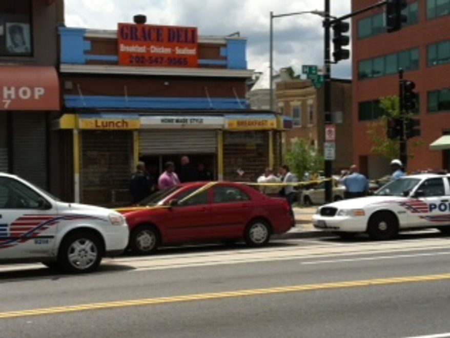 Police investigate the scene of an apparent robbery and homicide at Grace Deli on the 700 block of Grace Street Northeast. (Andrea Noble/The Washington Times)
