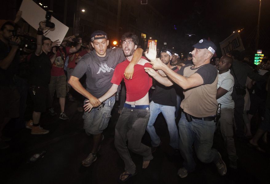 Israeli police detain an activist during a social protest in Tel Aviv early on Sunday, June 24, 2012. (AP Photo/Dan Balilty)