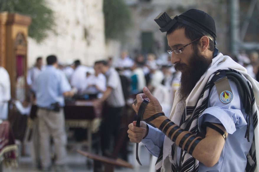 ** FILE ** In this Monday, July 2, 2012, an Israeli soldier prays next to the Western Wall, the holiest site where Jews can pray, in Jerusalem's Old City. (AP Photo/Dan Balilty)