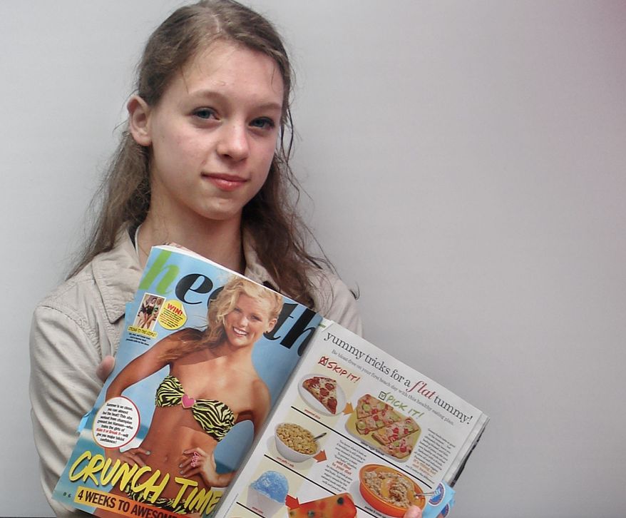 Julia Bluhm of Waterville, Maine, holds up a copy of "Seventeen" magazine as she leads a protest outside Hearst Corp. headquarters in New York. (Associated Press)