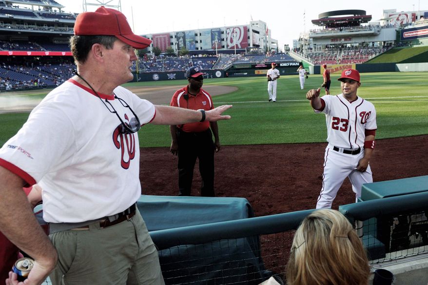Steve Wilson catches up with Nationals catcher Jhonatan Solano, one of the players who has stayed with the Wilsons, before a game at Nationals Park. Phyllis Wilson (below) says, "They do mean a lot to you." This year, the family was unable to host players because their daughter gave birth to their first grandchild. Above right, a collection of mementos decorates the Wilsons' basement. (Preston Keres/Special to The Washington Times)