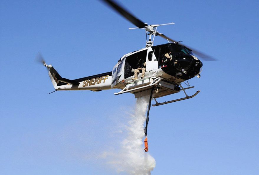 Washoe County Sheriff's Office
This HH-1H Huey helicopter, the jewel of the Regional Aviation Enforcement Unit in Washoe County, Nev., failed to act during the Pinehaven wildfire last week because of a tangle of federal rules.