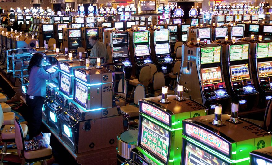 **FILE** Workers put the finishing touches on slot machines at Hollywood Casino, in Perryville, Md. (Associated Press)