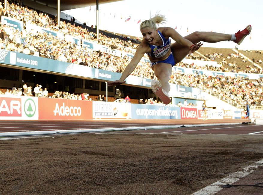FILE- Greece's Voula Papachristou soars through the air in the Women's Triple Jump final at the European Athletics Championships in Helsinki, Finland, in this file photo dated Friday, June 29, 2012. The Hellenic Olympic Committee has removed triple jumper Voula Papachristou from the team taking part in the upcoming London Olympic Games over comments she made on twitter making fun of African immigrants and expressing support for a far-right party. “The track and field athlete Paraskevi (Voula) Papachristou is placed outside the Olympic Team for statements contrary to the values and ideas of the Olympic movement,” a statement by the Hellenic Olympic Committee says. Papachristou is in Athens, and was to travel to London “shortly before the track events start,” the announcement says.(AP Photo/Matt Dunham, file)