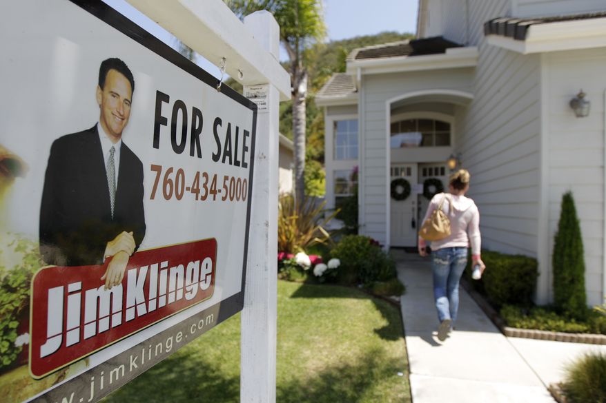 **FILE** A woman walks to an open house in San Diego on June 13, 2012. (Associated Press)