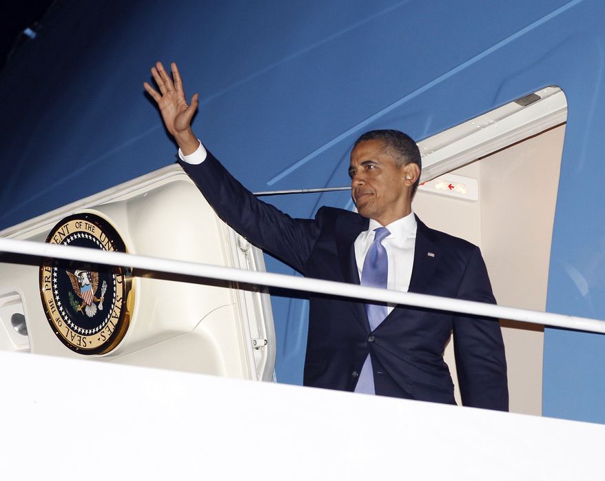 President Obama waves July 30, 2012, as he boards Air Force One before his departure from JFK International airport in New York. Obama traveled to New York for a private fundraiser. (Associated Press)