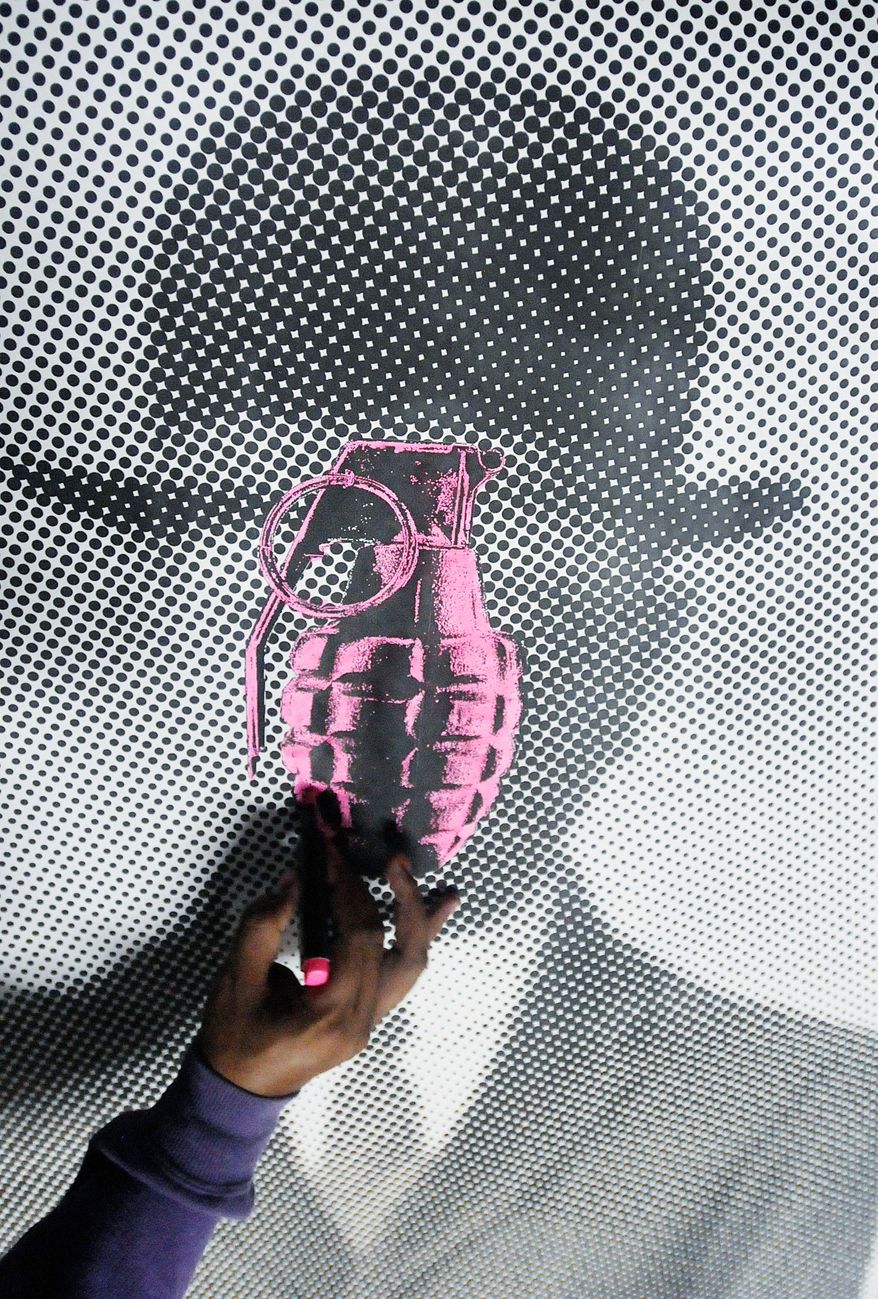 In this July 29, 2012 photo, an artist who calls himself the Urban Maeztro and prefers to remain anonymous for security reasons, works on a reproduction of Rene Magritte's "Son of Man," substituting the apple covering the face of the suited subject in a bowler hat with a pink grenade, at his studio in Tegucigalpa, Honduras. The 26-year-old graphic artist left his day job at an advertising agency to work on pieces like this one, to encourage Hondurans think about how violent their country has become. (AP Photo/Fernando Antonio)
