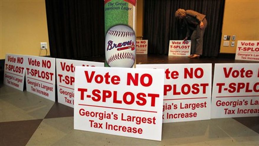 Debbie Dooley, co-founder of the Atlanta Tea Party, sets out signs and waits for returns where T-SPLOST opposition groups gather for a election night watch at Hudson Grille in Atlanta on Tuesday, July 31, 2012. This and other battles are evidence of the latest phase of the conservative movement, influencing state and local policy, perhaps more effectively than on a national level. (AP Photo/Atlanta Journal-Constitution, Curtis Compton)
