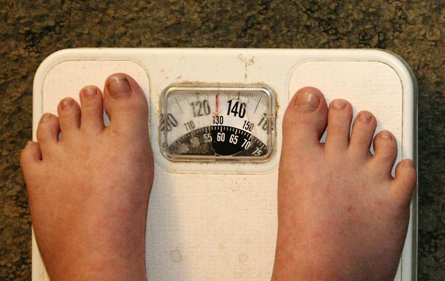 Eight-year-old Gabriel Omans of Anniston, Ala., stands on a scale on Monday, July 16, 2012. (AP Photo/The Anniston Star, Trent Penny )