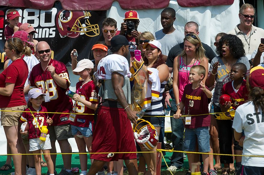 Redskins wide receiver Santana Moss is greeted by fans as he makes his way to the practice field during the Redskins training camp at Redskins Park in Ashburn, Va., Monday, August 13, 2012. (Rod Lamkey Jr./The Washington Times)