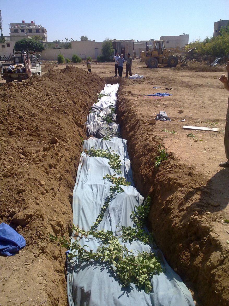 This citizen journalism image from Aug. 26, 2012, provided by Shaam News Network SNN, purports to show victims killed by shabiha pro-government militiamen being buried in a mass grave in Daraya, Syria. According to activists' accounts, government forces retook the Damascus suburb of Daraya from rebel control three days prior and went on a killing spree. Reports of the death toll range widely from more than 300 to as many as 600. (Associated Press/Shaam News Network)