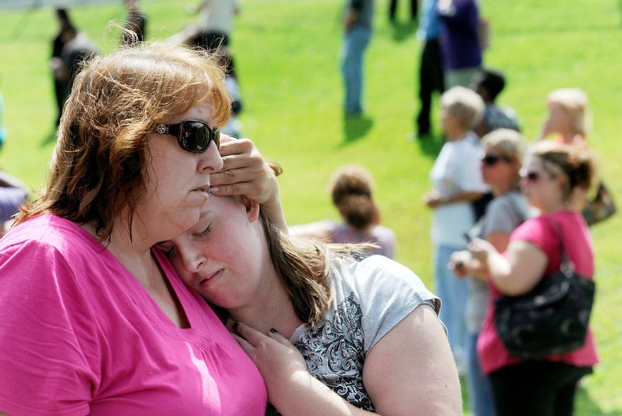 Tracie Bradford, of Perry Hall, Md., consoles her daughter Leah, a student at Perry Hall High School who says she was in the school's cafeteria when a student was shot there and critically wounded on the first day of classes. (AP Photo/Steve Ruark)