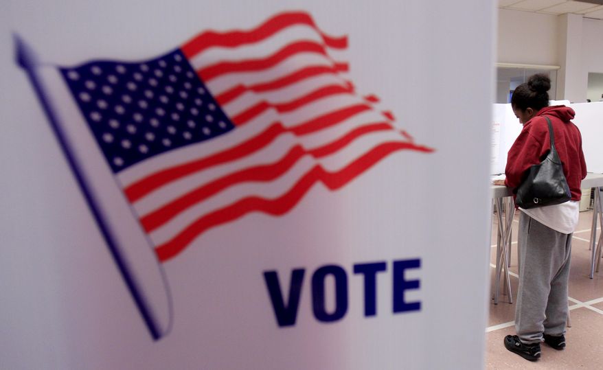 **FILE** A woman votes Jan. 31, 2012, at the Cuyahoga County Board of Elections in Cleveland as early voting began in Ohio's March 6 presidential primary. (Associated Press)