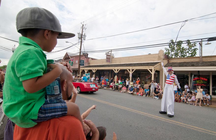 Patriotic performers wave to spectators in the Gaithersburg end-of-summer festivity, Monday, Sept. 3, 2012. (Craig Bisacre/The Washington Times)