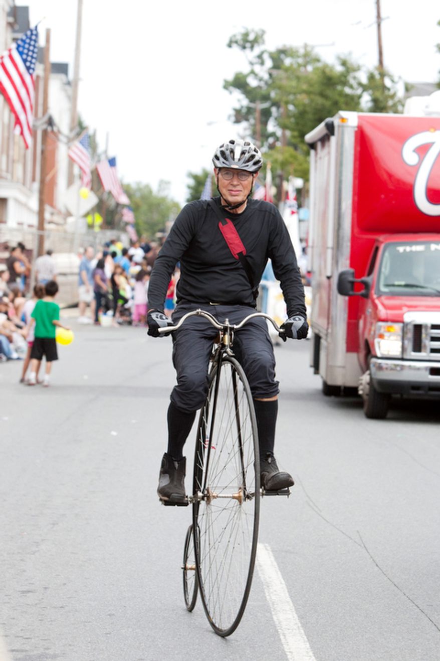 A high wheel bicycle rider peddles down E. Diamond Ave. (Craig Bisacre/The Washington Times)