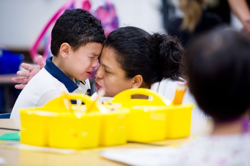 Sandra Mejia comforts her son Carlos Jiron, 5, on his first day of kindergarden. (Andrew Harnik/The Washington Times)