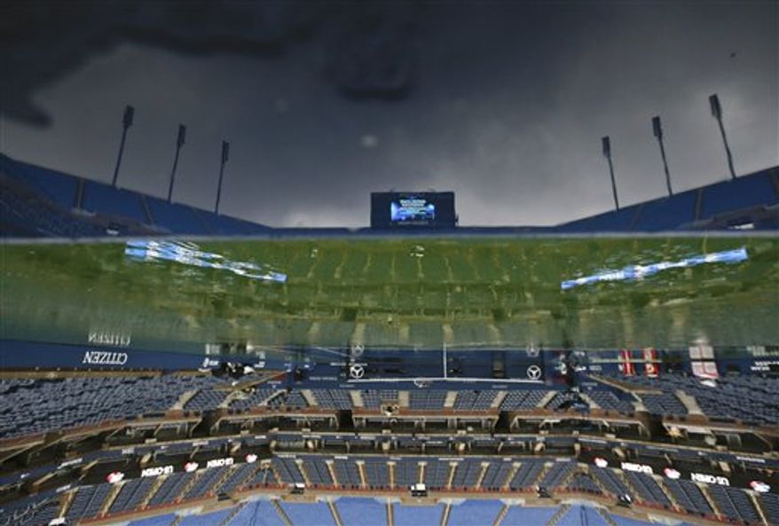The tennis court at Arthur Ashe stadium is shown as rain falls before play is to resume at the 2012 US Open tennis tournament, Saturday, Sept. 8, 2012, in New York. (AP Photo/Charles Krupa)