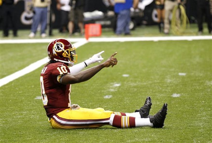 Robert Griffin III celebrates his first career touchdown pass, an 88-yard completion to Pierre Garcon (Associated Press)