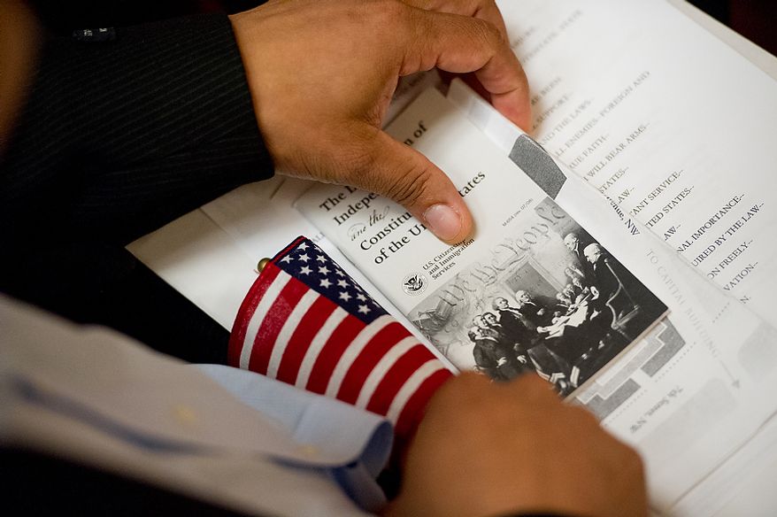 A petitioner holds a pamphlet on the Declaration of Independence and the Constitution of the United states as he and 224 others wait to be sworn in as U.S. citizens on Sept. 17, 2012, at the National Archives Building in Washington, during a naturalization ceremony to commemorate the 225th anniversary of the signing of the U.S. Constitution. (Andrew Harnik/The Washington Times)