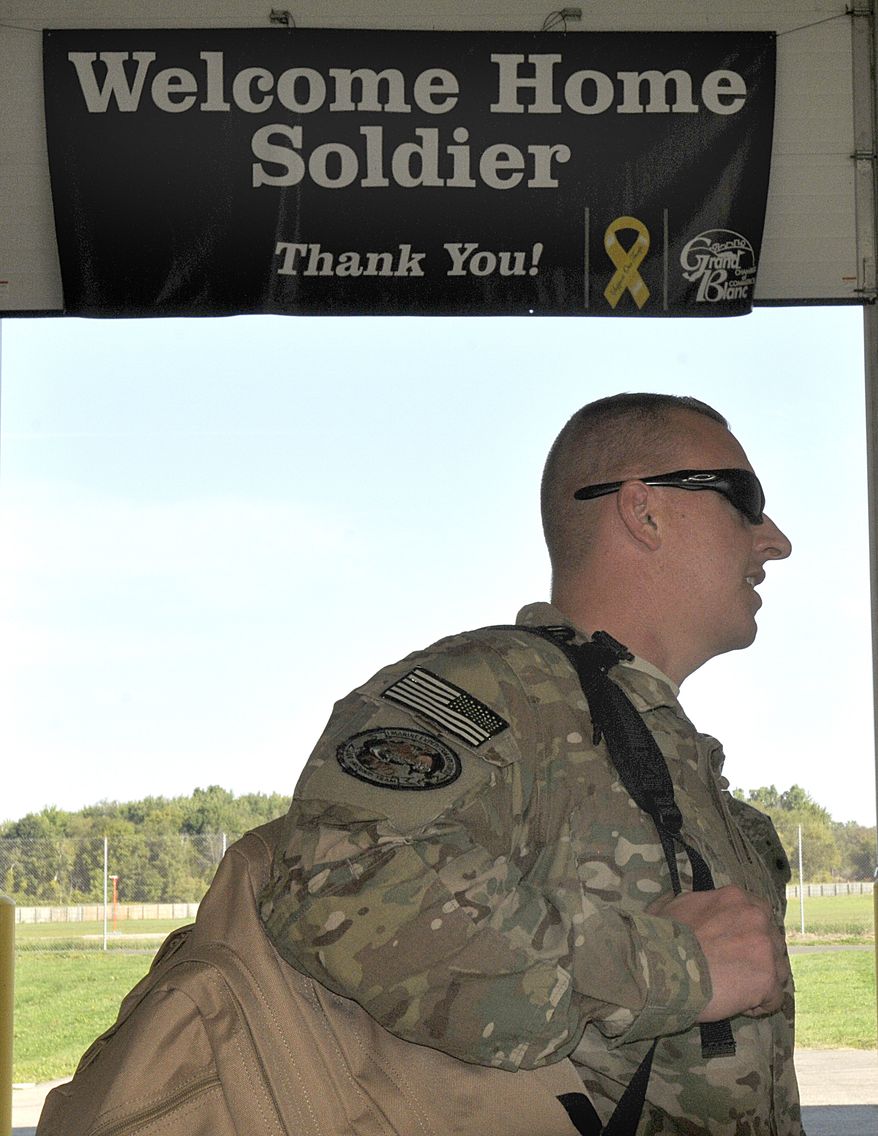 Army SFC David Schopp, of Plymouth, Mich. returns Sept. 16, 2012, from a yearlong deployment in Afghanistan in Lansing, Mich. About 80 troops arrived at Capital City Air International Airport. (Associated Press/The State Journal)