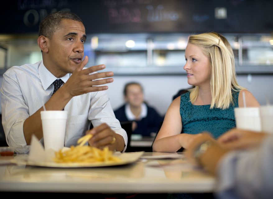 President Obama talks with Emily Young, first-time voter and student at University of Miami, on Sept. 20, 2012, at OMG Burger in Miami. (Associated Press)