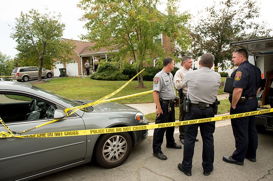 Fairfax police officers investigate the death of four family members discovered around 12pm after individuals had failed to show up to work, Herndon, Va., Tuesday, September 25, 2012. (Andrew Harnik/The Washington Times)