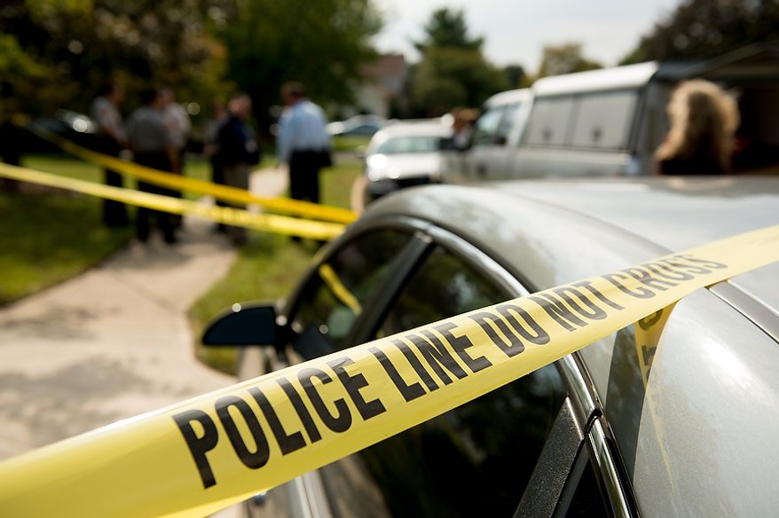 Fairfax police officers investigate the death of four family members discovered around 12pm after individuals had failed to show up to work, Herndon, Va., Tuesday, September 25, 2012. (Andrew Harnik/The Washington Times)