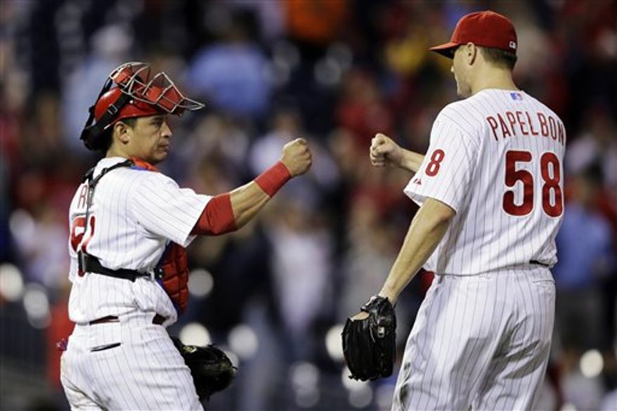 Philadelphia Phillies catcher Carlos Ruiz, left, and relief pitcher Jonathan Papelbon celebrate their 6-3 win in a baseball game against the Washington Nationals, Tuesday, Sept. 25, 2012, in Philadelphia. (AP Photo/Matt Slocum)