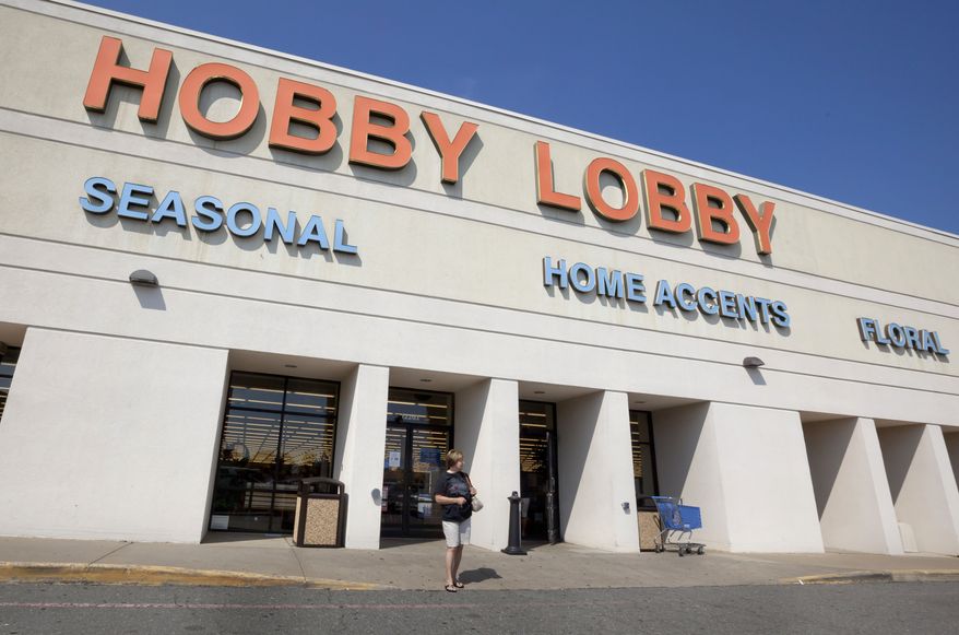 ** FILE ** A woman leaves a Hobby Lobby store in Little Rock, Ark., on Sept. 12, 2012. (Associated Press)