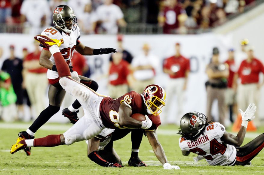 Washington Redskins tight end Logan Paulsen (82) gets taken down by Tampa Bay Buccaneers strong safety Mark Barron (24) and free safety Ronde Barber (20) during the fourth quarter. (AP Photo/Chris O'Meara)