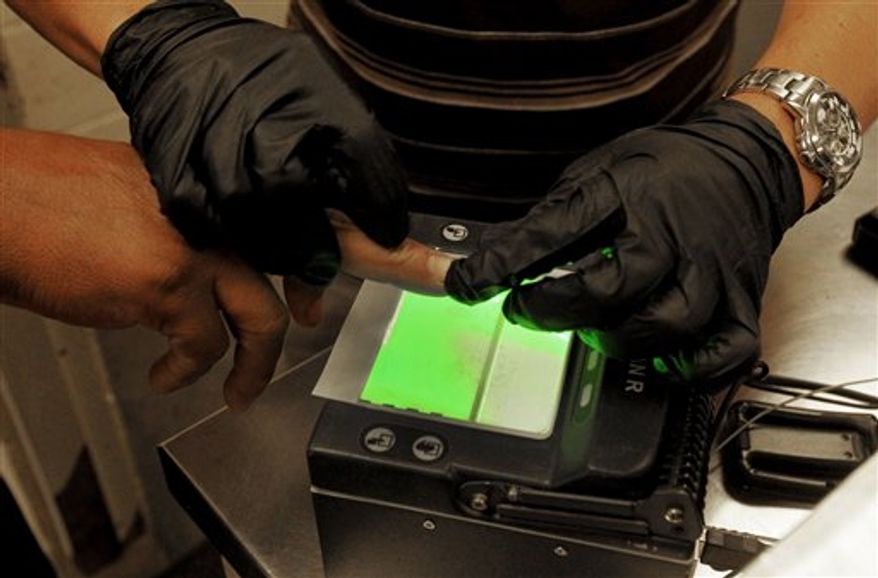 **FILE** An illegal immigrant is fingerprinted Aug. 9, 2012, as part of processing in order to create or update a file on that immigrant at Tucson Sector U.S. Border Patrol Headquarters in Tucson, Ariz. (Associated Press)