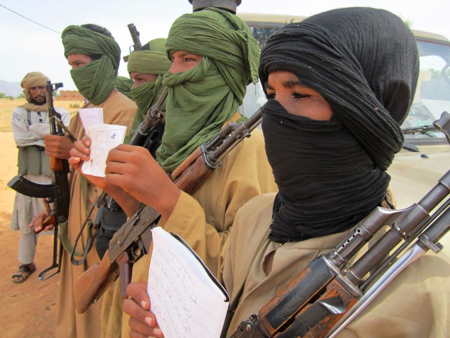 Young fighters, including 13-year-old Abdullahi (right) and 14-year-old Hamadi (second right), display their Quranic studies notes for a journalist as their Islamist commanders watch in Douentza, Mali, on Sept. 27, 2012. (Associated Press)