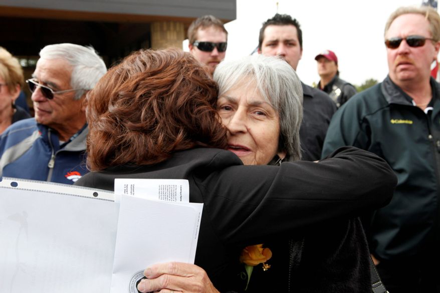 Delouise Guerra, right, the sister of Marine PFC James Jacques is hugged by a family member after his funeral at Fort Logan National Cemetery in Denver. (AP Photo/Ed Andrieski)