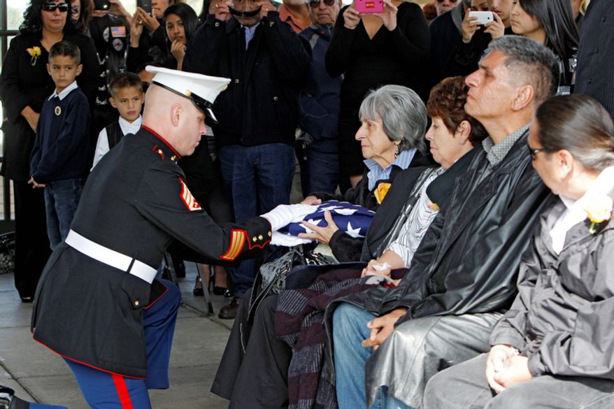 Delouise Guerra the sister of Marine PFC James Jacques is presented the flag that draped his casket at Fort Logan National Cemetery in Denver on Tuesday, Oct. 9, 2012. (AP Photo/Ed Andrieski)