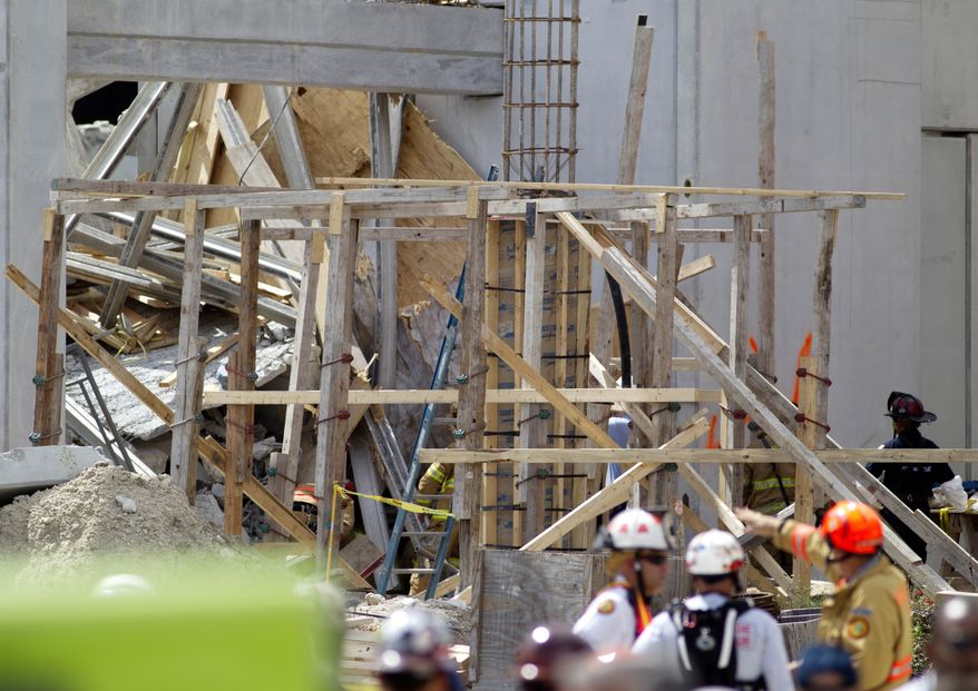 Firefighters examine the rubble Oct. 10, 2012, after a section of a parking garage under construction at Miami-Dade College in Doral, Fla., collapsed, killing one worker and trapping at least two others. (Associated Press)