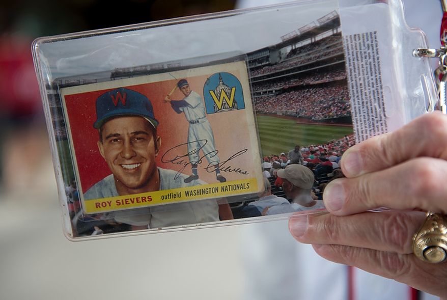 A Washington Nationals fan holds up his 1955 Roy Sievers baseball card on Wednesday, Oct. 10, 2012 during the National League Division Series game at Nationals Park. (Barbara L. Salisbury/The Washington Times)