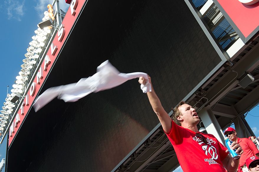 Mark Bresny of Fairfax, Va. waves a t-shirt in the air to try to rally fellow Nationals fans during the third game of the National League Division Series at Nationals Park on Wednesday, Oct. 10, 2012. (Barbara L. Salisbury/The Washington Times)