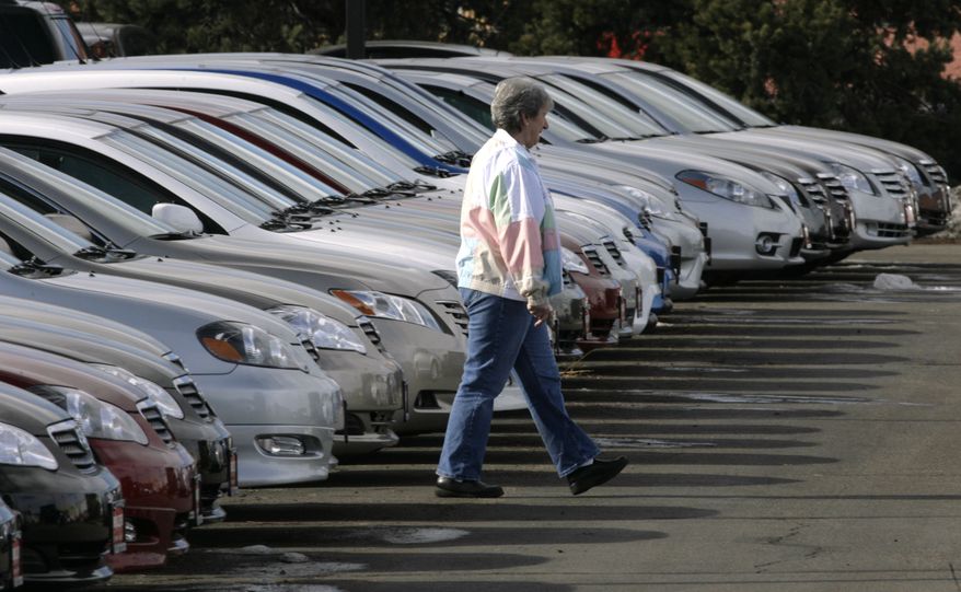 A prospective buyer searches through long lines of unsold Corolla and Camry sedans at a Toyota dealership in Boulder, Colo., in 2007. (AP Photo/David Zalubowski)