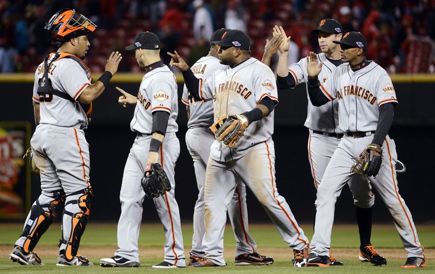 San Francisco Giants players celebrate after defeating the Cincinnati Reds 8-3 in Game 4 of the National League division baseball series, Wednesday, Oct. 10, 2012, in Cincinnati. (AP Photo/Michael Keating)