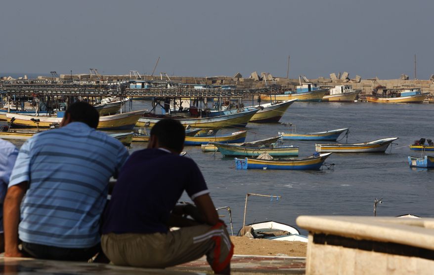 **FILE** Palestinians sit by the port in Gaza City on Oct. 17, 2012. (Associated Press)