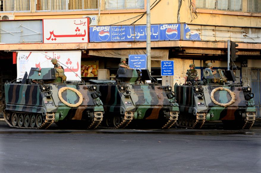 Lebanese Army soldiers monitor clashes that erupted between supporters and opponents of the Syrian regime on Oct. 22, 2012, in the northern port city of Tripoli, Lebanon. Lebanese troops launched a major security operation to open all roads and force gunmen off the streets, trying to contain an outburst of violence set off by the assassination of a top intelligence official who was a powerful opponent of Syria. (Associated Press)