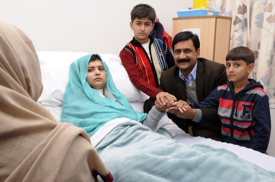 Malala Yousufzai sits in her hospital bed as her father, Ziauddin (second from right), accompanied by her two younger brothers, Atal (right) and Khushal, sit by, in this undated photo issued by Queen Elizabeth Hospital in Birmingham, England, on Friday, Oct. 26, 2012. The 15-year-old Pakistani girl, who was shot in the head Oct. 9 in Pakistan by the Taliban, is recovering at the Birmingham hospital, where she was flown for treatment and protection from Taliban threats. (Associated Press/Queen Elizabeth Hospital, Birmingham)