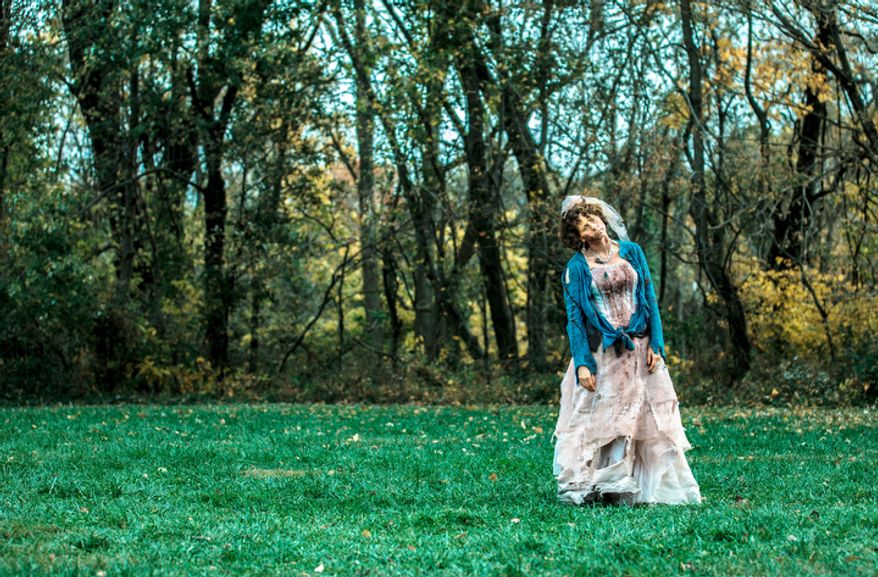Lisa Renard-Spicer, a zombie volunteer, stands hauntingly in an open field preparing for runners to move past here at Run for Your Lives, a zombie infested 5k obstacle course run, in Darlington, MD. (Andrew S. Geraci/The Washington Times)