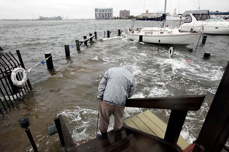 Norfolk, Va., resident Jack Devnew looks at the water covering a dock as he checks on his boat at a marina near downtown on Monday, Oct. 29, 2012. Rain and wind from Hurricane Sandy were hitting the area. (AP Photo/Steve Helber)