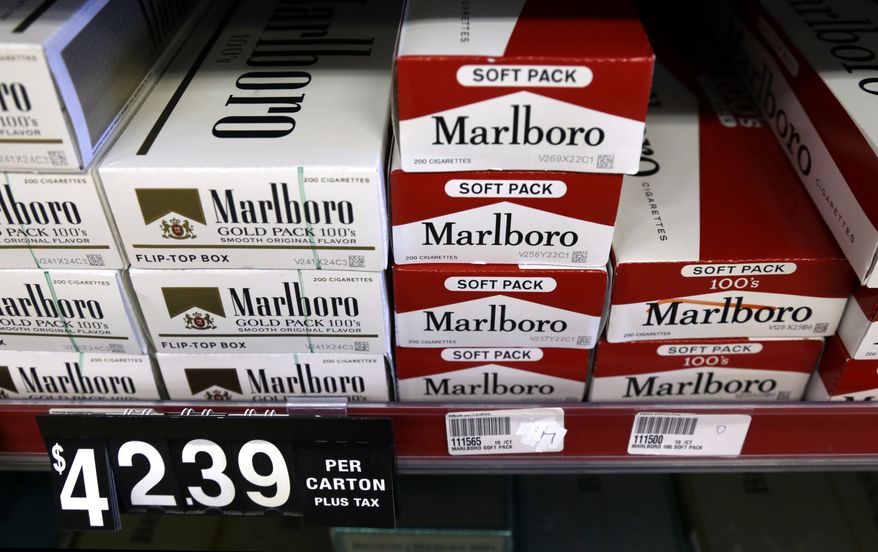 **FILE** Cartons of cigarettes sit on shelves at Discount Smoke Shop on Oct. 31, 2012, in Ballwin, Mo. (Associated Press)
